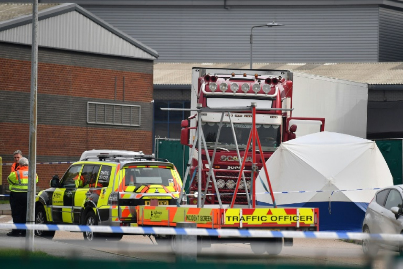 Des policiers britanniques se tiennent près d'un camion charnier dans lequel 39 migrants vietnamiens ont trouvé la mort, le 23 octobre 2019 à Grays, au Royaume-Uni © Ben STANSALL