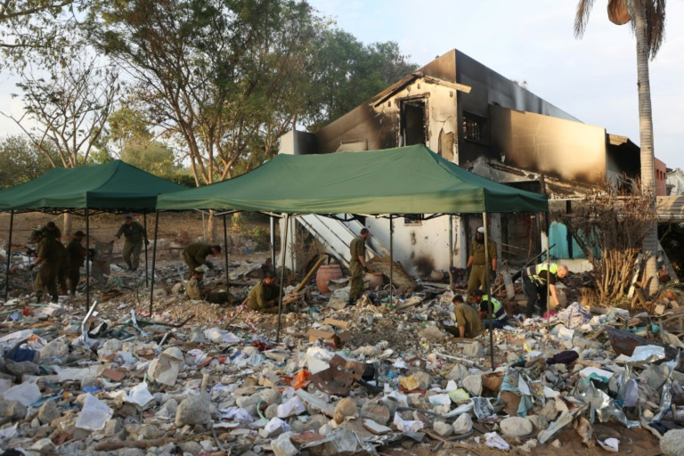 Des soldats israéliens et des bénévoles fouillent les débris dans le kibboutz Beeri, près de la frontière avec Gaza, le 12 novembre 2023, à la suite d'une attaque du Hamas le 7 octobre © GIL COHEN-MAGEN