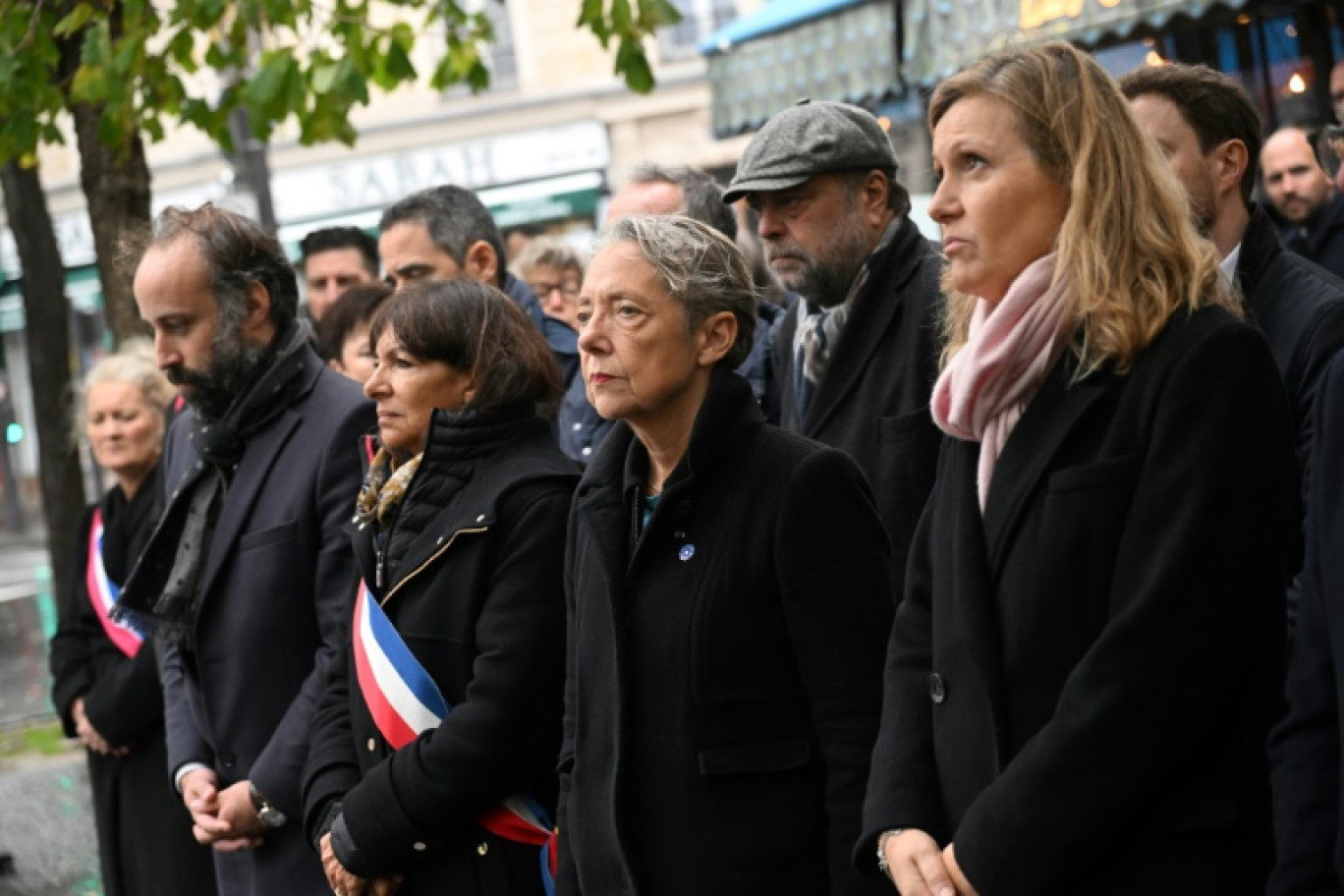 De gauche à droite, le président de l'association Life for Paris Arthur Dénouveaux, la maire de Paris Anne Hidalgo, la Première ministre Elisabeth Borne et la présidente de l'Assemblée nationale Yaël Braun-Pivet, se recueillent devant le "Comptoir Voltaire", l'un des bars visés lors des attaques terroristes du 13 novembre 2015, à Paris le 13 novembre 2023 © Bertrand GUAY