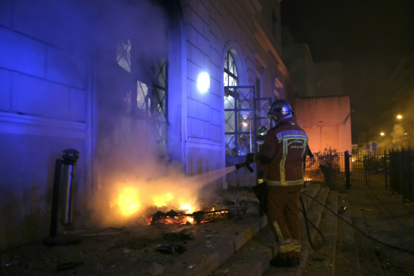 Un pompier éteint un incendie provoqué par des manifestants au palais de justice d'Ajaccio, en Corse, le 9 mars 2022 © Pascal POCHARD-CASABIANCA