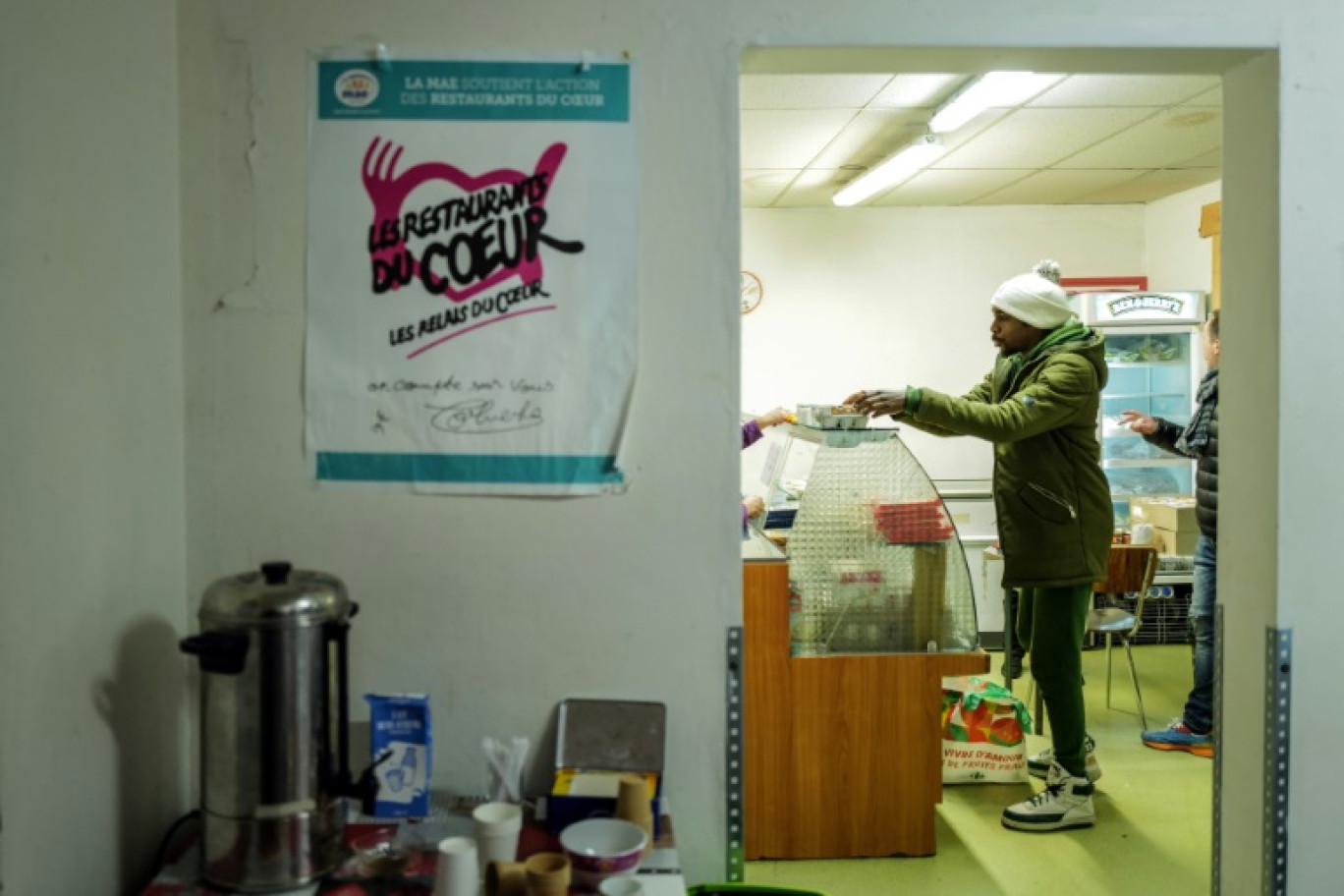 Un homme reçoit un repas au centre des Restos du Coeur de Grenoble, le 21 novembre 2023 © OLIVIER CHASSIGNOLE