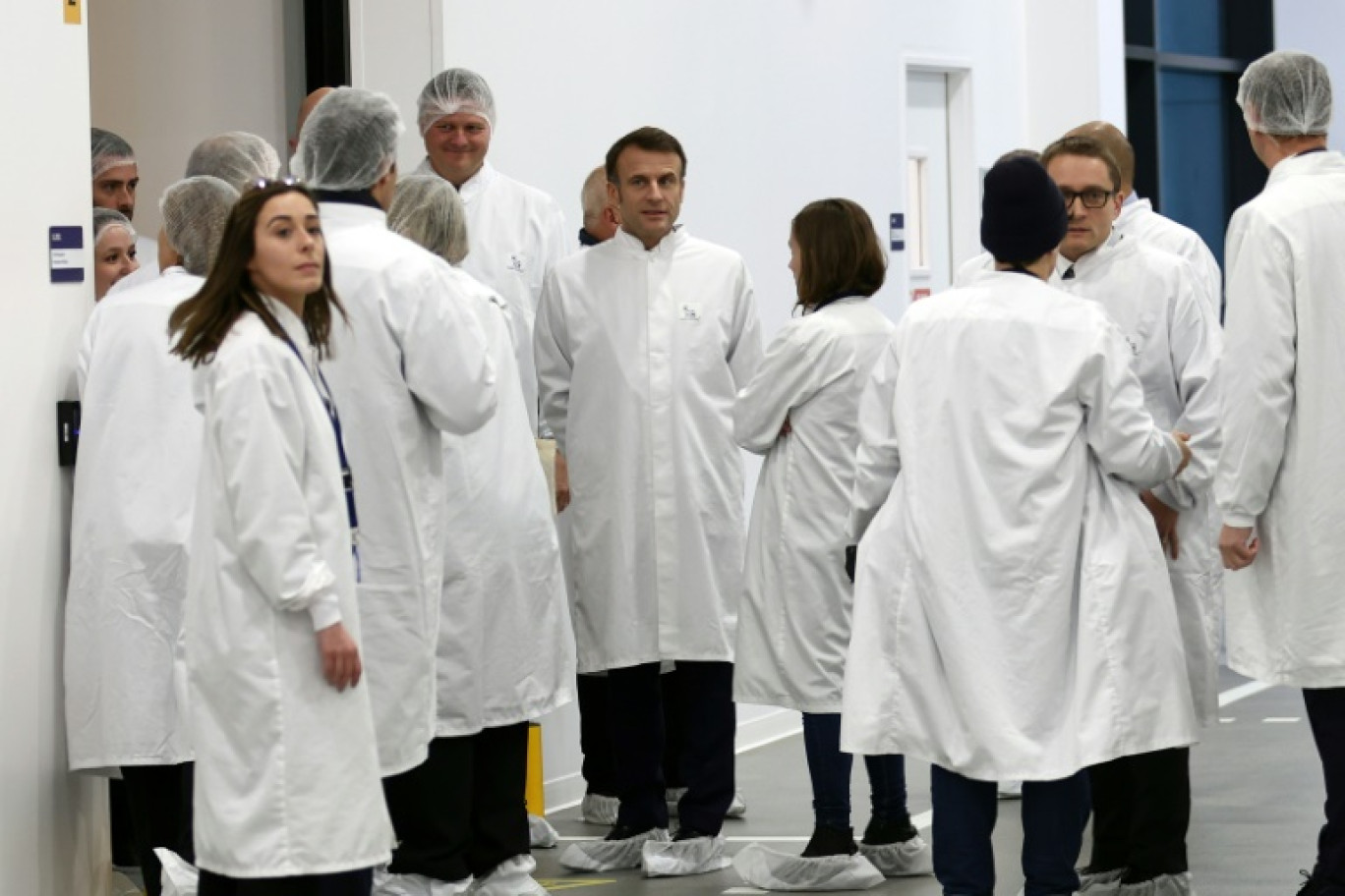 Le président Emmanuel Macron, au centre, attend avant la visite de l'usine de production de médicaments du danois Novo Nordisk à Chartres, en Eure-et-Loir, le 23 novembre 2023 © Mohammed BADRA