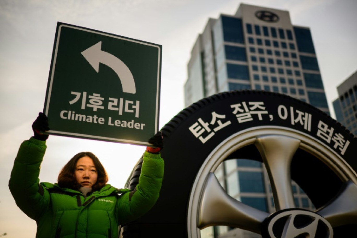 Une militante de Greenpeace lors d'une action de protestation contre les SUV devant le siège du géant automobile sud-coréen Hyundai à Séoul le 29 novembre 2023 © ANTHONY WALLACE