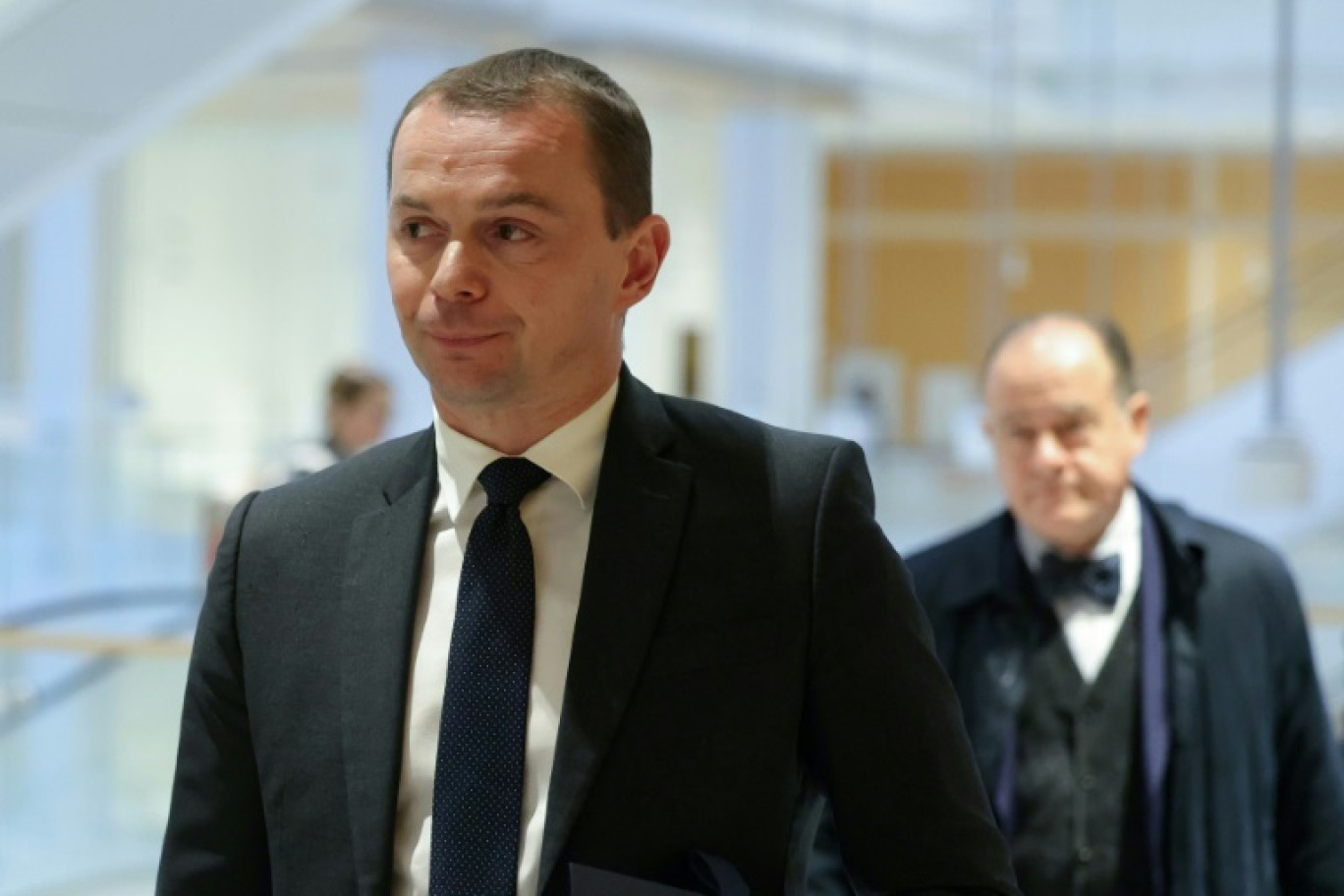 Le ministre du Travail Olivier  Dussopt (G) arrive avec son avocat Georges Holleaux (D) au tribunal de Paris le 27 novembre 2023 © Thomas SAMSON