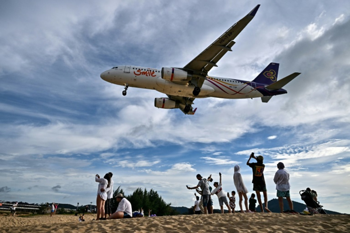 Des touristes sur la plage de Mai Khao, sur l'île de Phuket, près de l'aéroport international, le 18 novembre 2023 en Thaïlande © Lillian SUWANRUMPHA