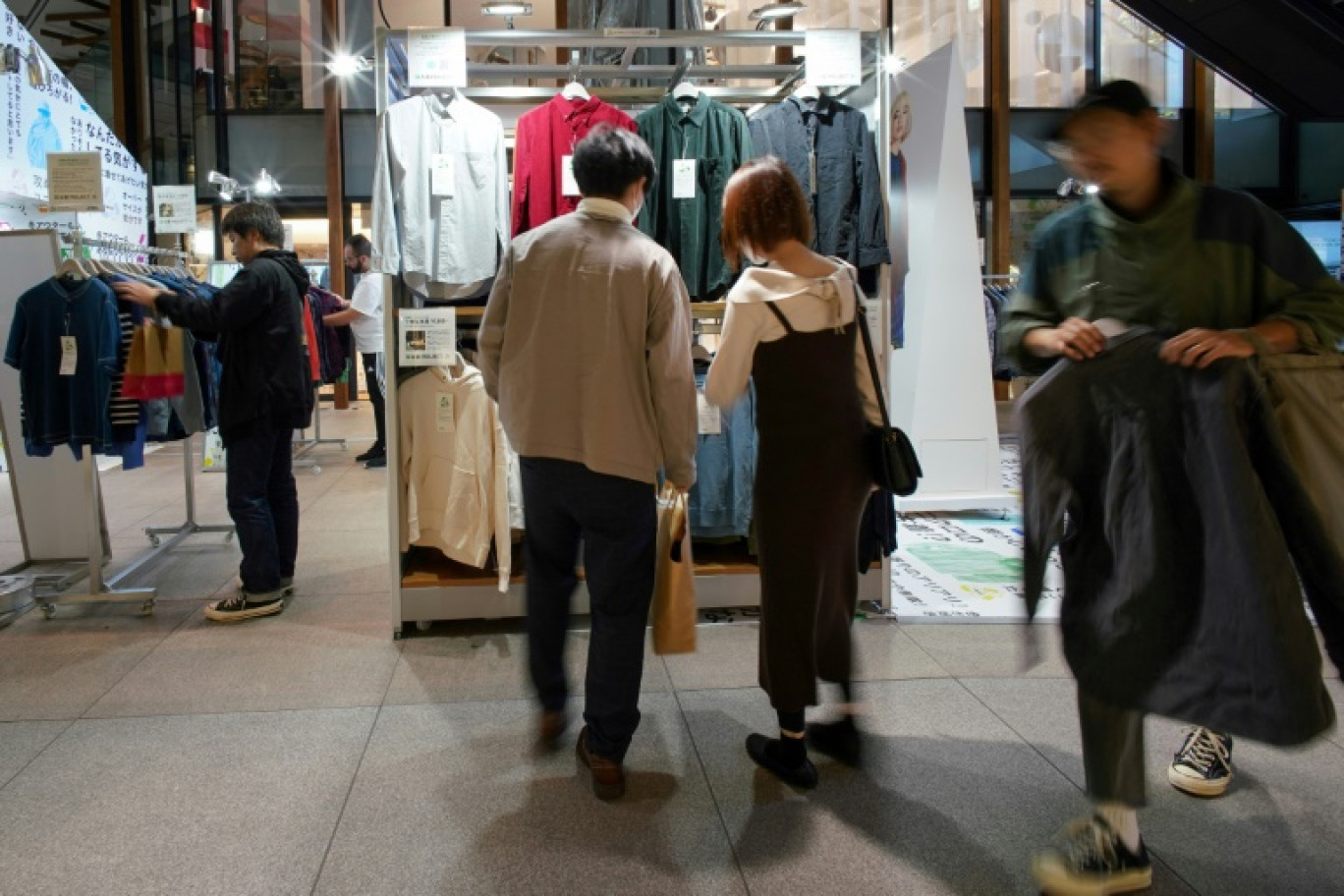 Des clients regardent des articles de seconde main de la marque japonaise Uniqlo vendus dans un pop-up store, le 17 octobre 2023 à Tokyo © Kazuhiro NOGI