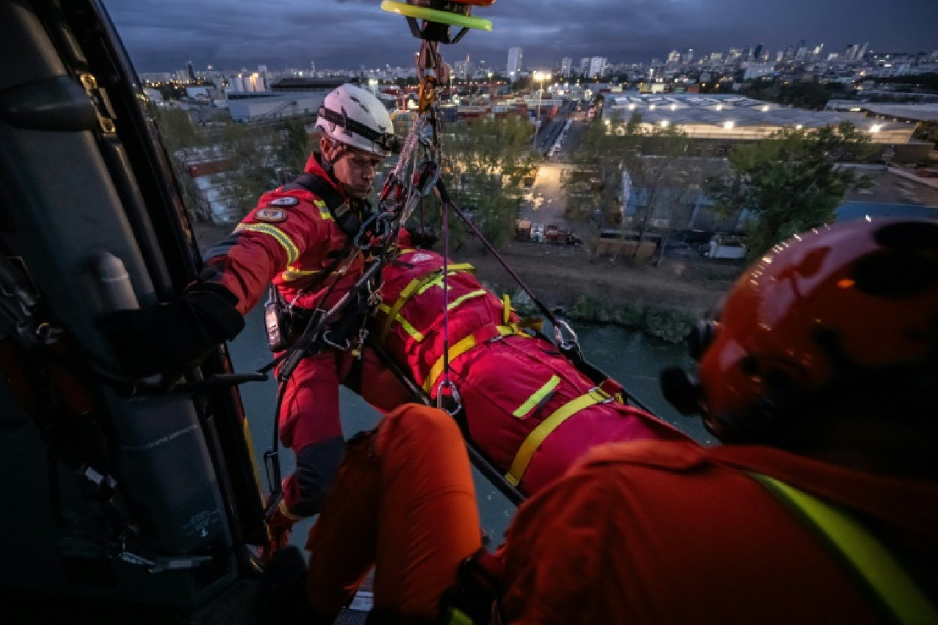 Des pompiers du GRIMP devant un hélicoptère Airbus EC145 de la Sécurité Civile française lors de manœuvres au port de Gennevilliers dans les Hauts-de-Seine, le 20 octobre 2023 © BERTRAND GUAY