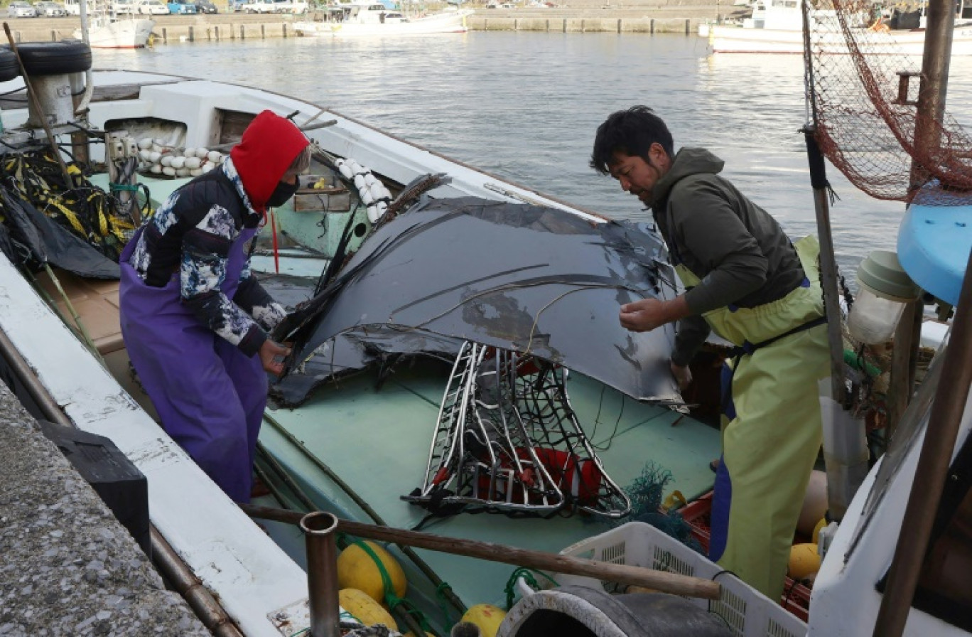 Des personnels militaires américains transportent un canot pour participer aux recherches en mer de l'épave d'un Osprey, sur l'île de Yakushima au Japon le 1er décembre 2023 © STR