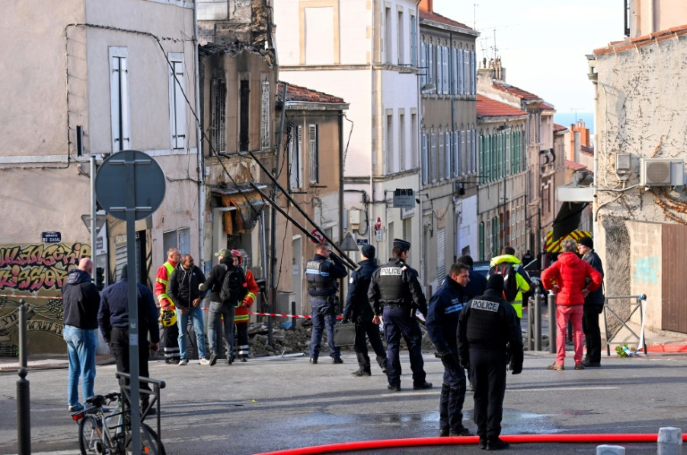 Des pompiers et policiers près d'un bâtiment partiellement détruit par un incendie qui s'est déclaré dans la nuit, le 3 décembre 2023 à Marseille, dans les Bouches-du-Rhône © NICOLAS TUCAT