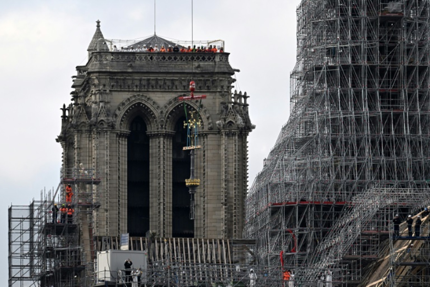 La croix de Notre-Dame de Paris soulevée par une grue pour être placée au sommet de la flèche de la cathédrale, le 6 décembre 2023, à Paris © Miguel MEDINA