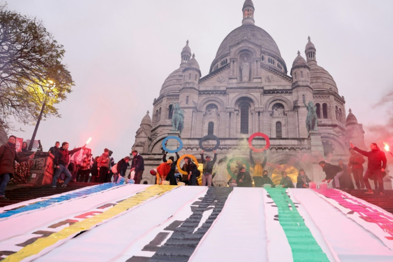 Des militants associatifs du groupe "Le Revers de la Medaille" manifestent devant le Sacré-Coeur, à Paris, le 15 décembre 2023 © Thomas SAMSON