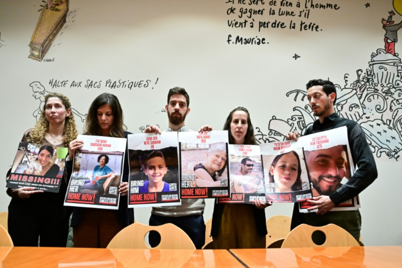 Des proches d'otages avec les photos des victimes, à droite le frère d'Elya Toledano, avec la photo d'Elya, à Paris le 31 octobre 2023 © Miguel MEDINA