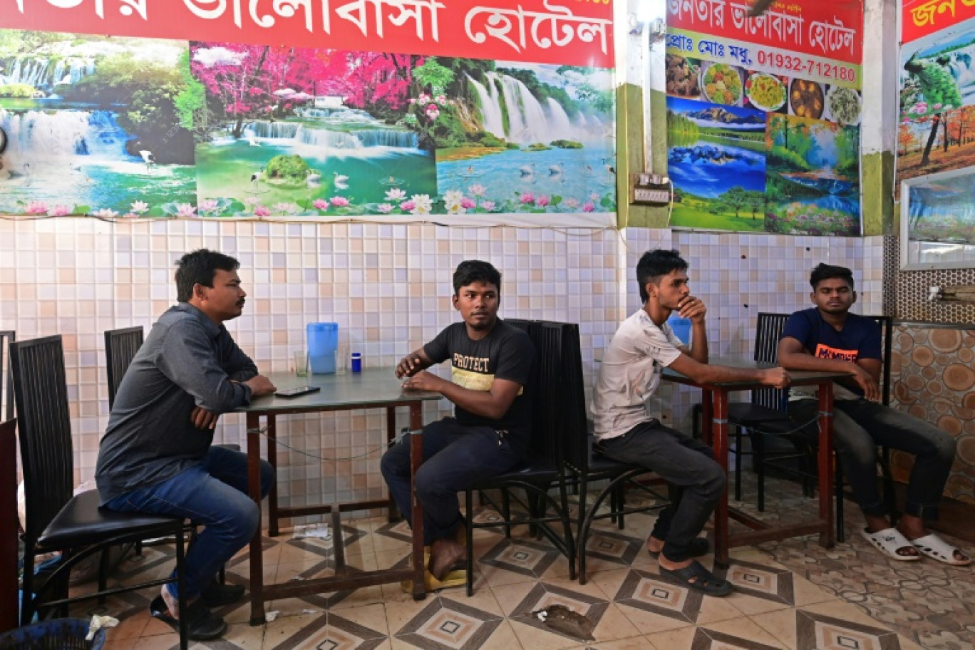 Naim Pramanik (G), ouvrier bangladais du textile de 28 ans, est assis à la table de Propid Ray, 38 ans, un dirigeant syndical qui a mené des manifestations, dans un restaurant de Dacca le 13 novembre 2023 © Munir UZ ZAMAN