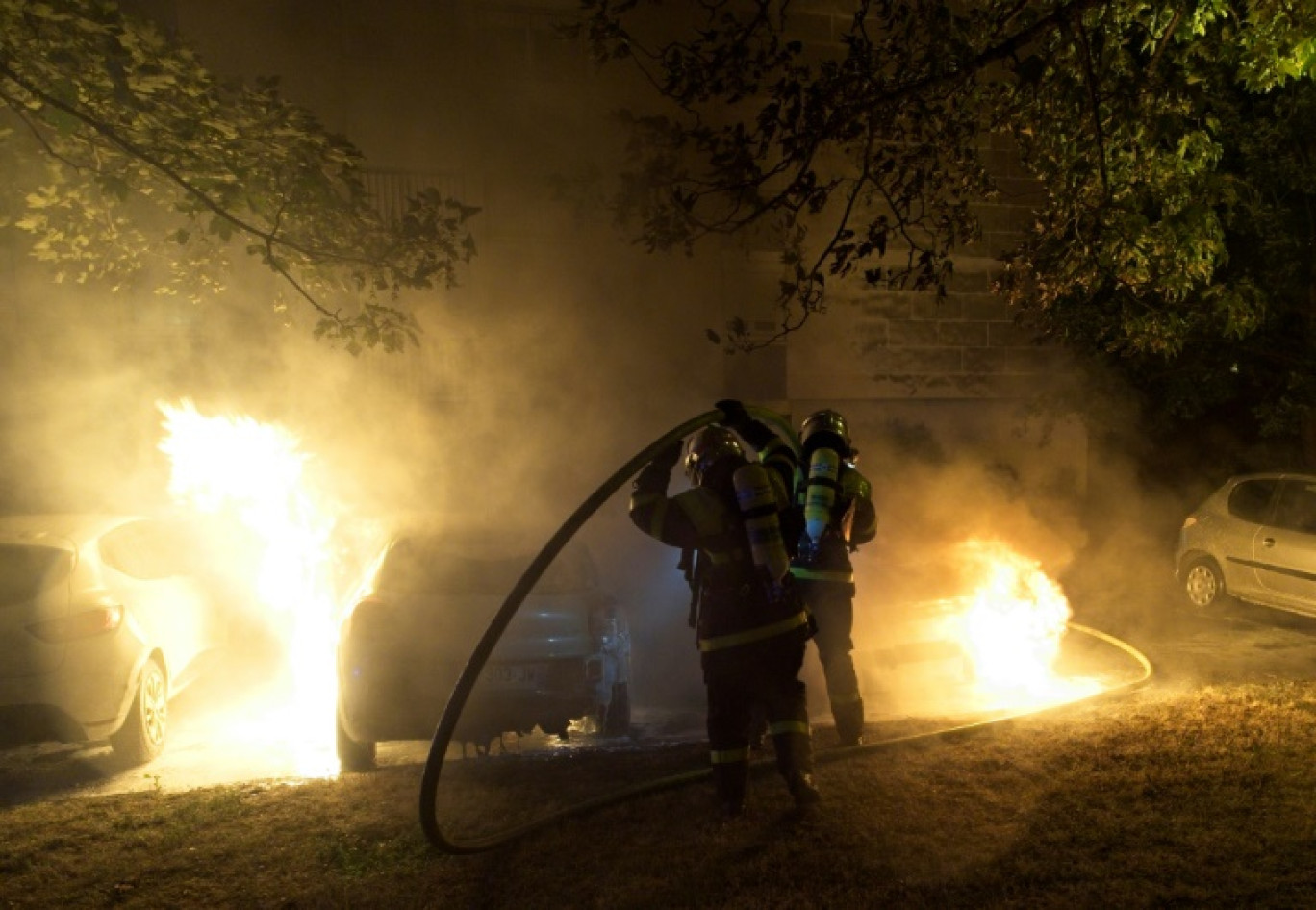 Des pompiers éteignent les flammes d'un véhicule lors de violences à Tours, le 30 juin 2023 © GUILLAUME SOUVANT