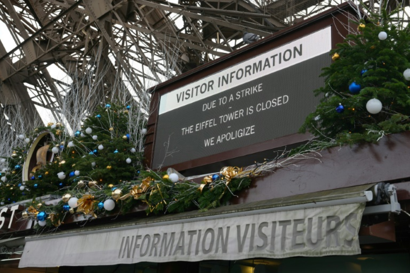 Cette photographie prise le 27 décembre 2023 montre un panneau informant les visiteurs que le site est fermé après une grève du personnel, au pied de la Tour Eiffel à Paris © Dimitar DILKOFF