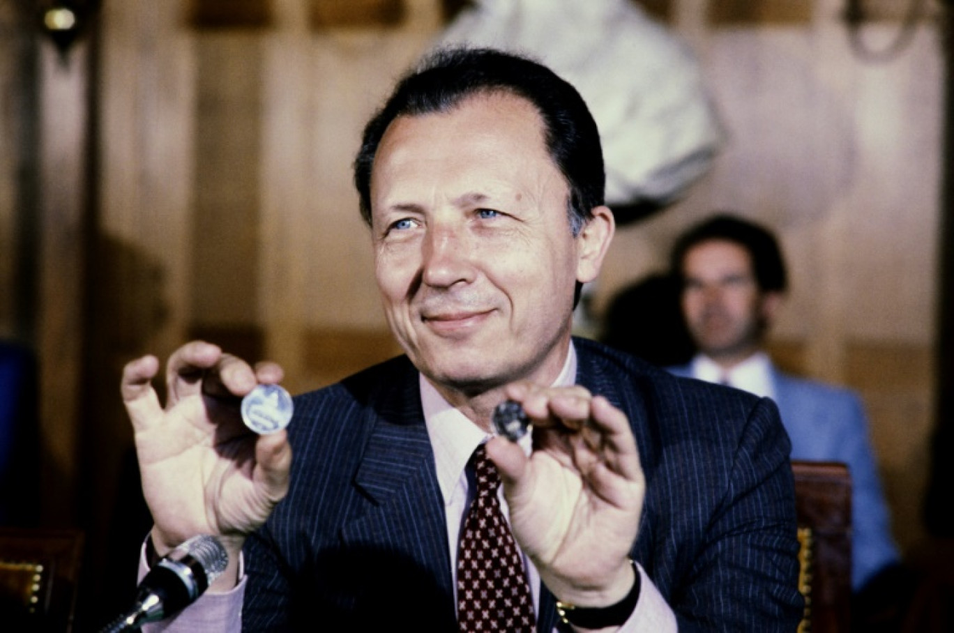 Jacques Delors, nouveau président de la Commission des Communautés européennes, présente la pièce de 100 francs, le 19 août 1982 à Paris © -