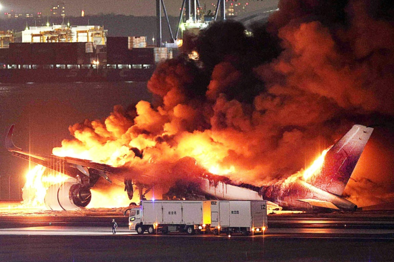 Un avion en feu sur une piste de l'aéroport international de Tokyo-Haneda le 2 janvier 2024 © STR