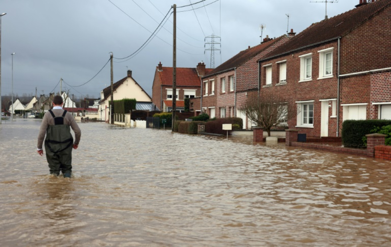 Un homme marche le 3 janvier 2024 dans une rue inondée d'Arques, dans le nord de la France, suite à la crue de l'Aa © Denis Charlet