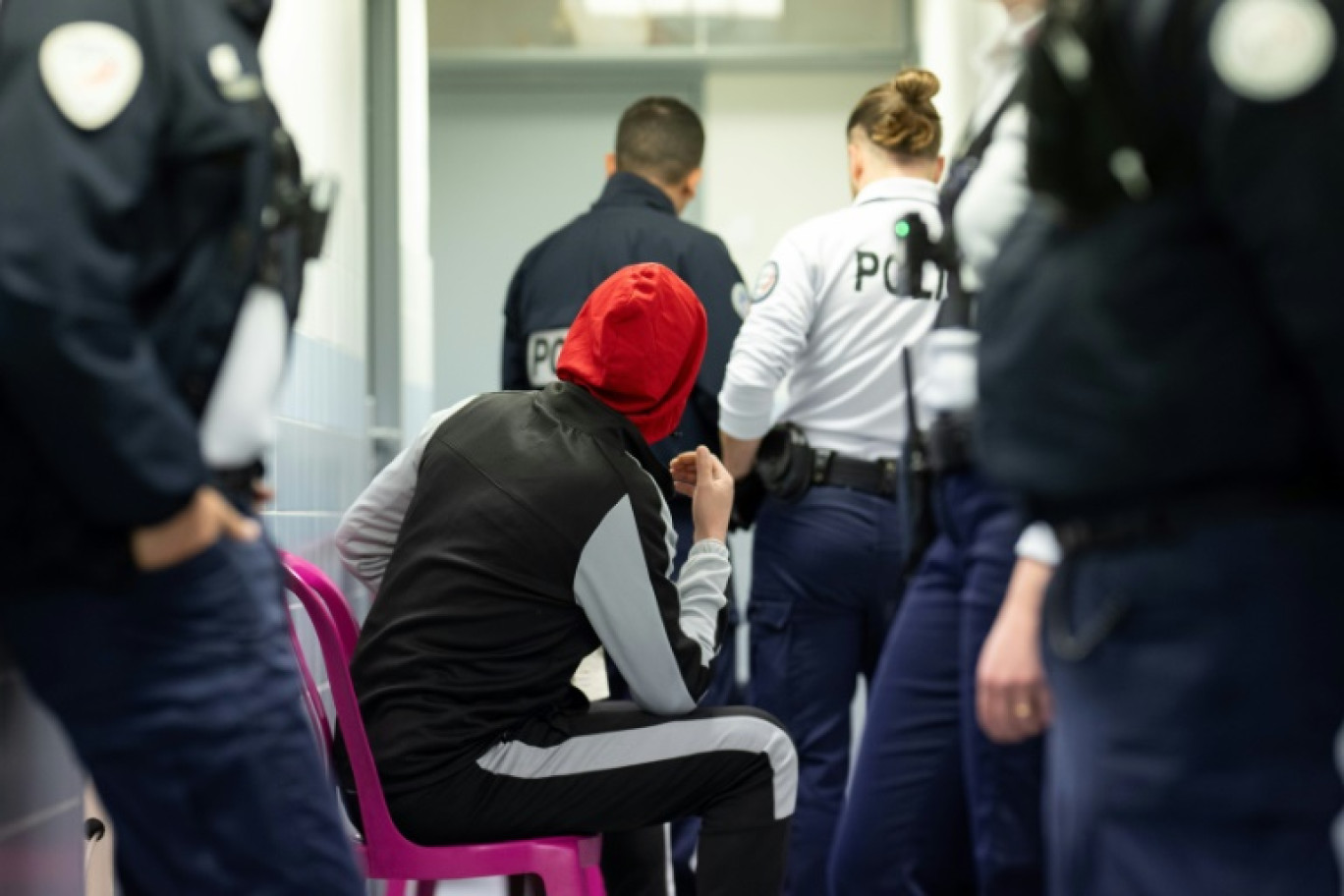 Un migrant attend, au milieu de policiers, devant l'infirmerie du centre de rétention administrative de Vincennes, à l'est de Paris, le 2 novembre 2023 © MIGUEL MEDINA