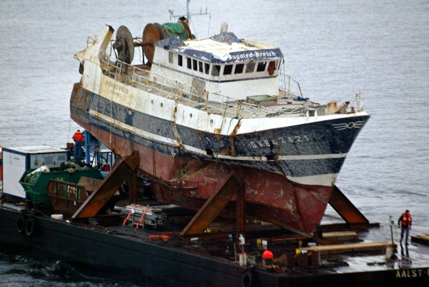 L'épave du "Bugaled Breizh" sur une barge tirée par un remorqueur de haute-mer, le 13 juillet 2004 à Brest, six mois après son naufrage © MARCEL MOCHET