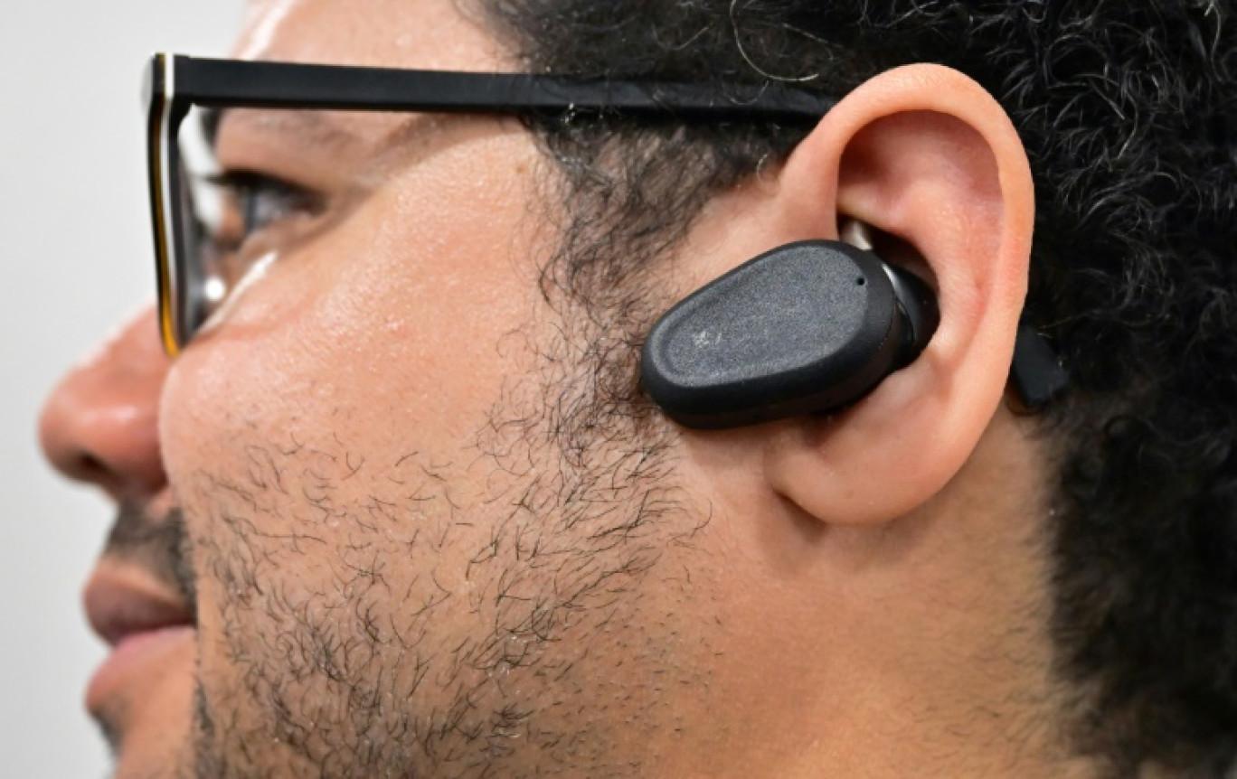 Un participant porte les "oreillettes neuronales" de Naqi Logix, censées permettre de contrôler des objets connectés par de simples mouvements du visage, au CES de Las Vegas, le 10 janvier 2024 © Frederic J. BROWN