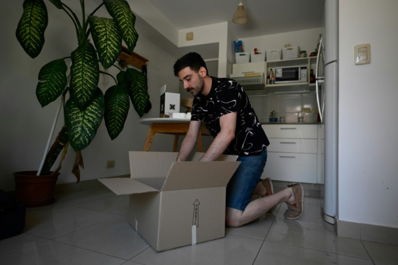 Tomas Sislian remplit des cartons alors qu'il se prépare à déménager d'un appartement loué, poussé par la crise immobilière en Argentine, le 8 janvier 2023 à Buenos Aires © Luis ROBAYO