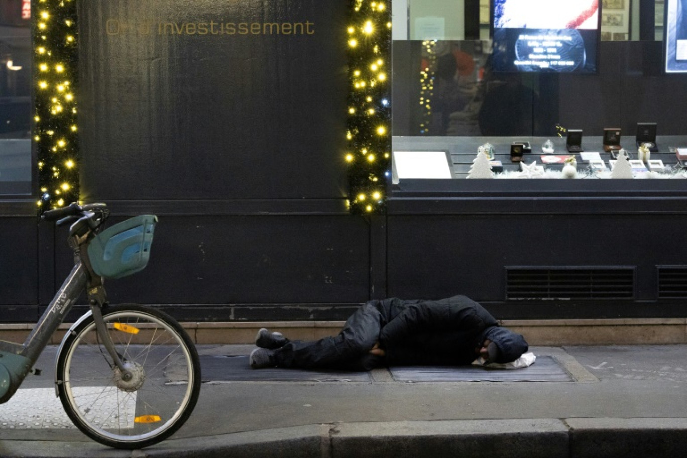 Une personne sans-abri dort sur un trottoir à Paris, le 8 janvier 2024, alors que les températures nocturnes sont négatives © Alain JOCARD