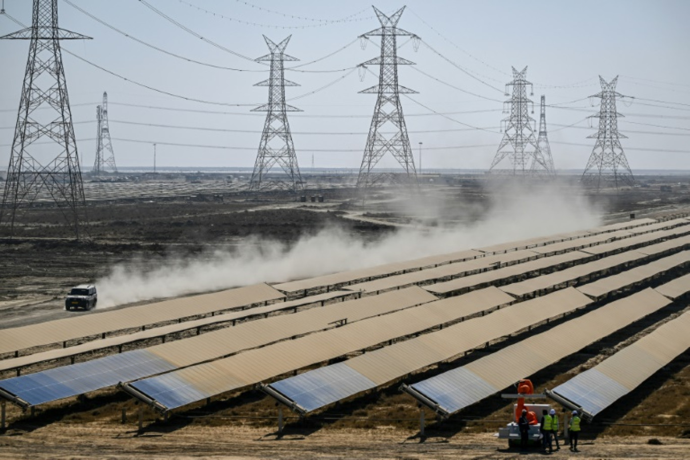 Des ouvriers installent des panneaux solaires pour le compte du groupe Adani à Khavda, en Inde, le 12 janvier 2024 © Punit PARANJPE