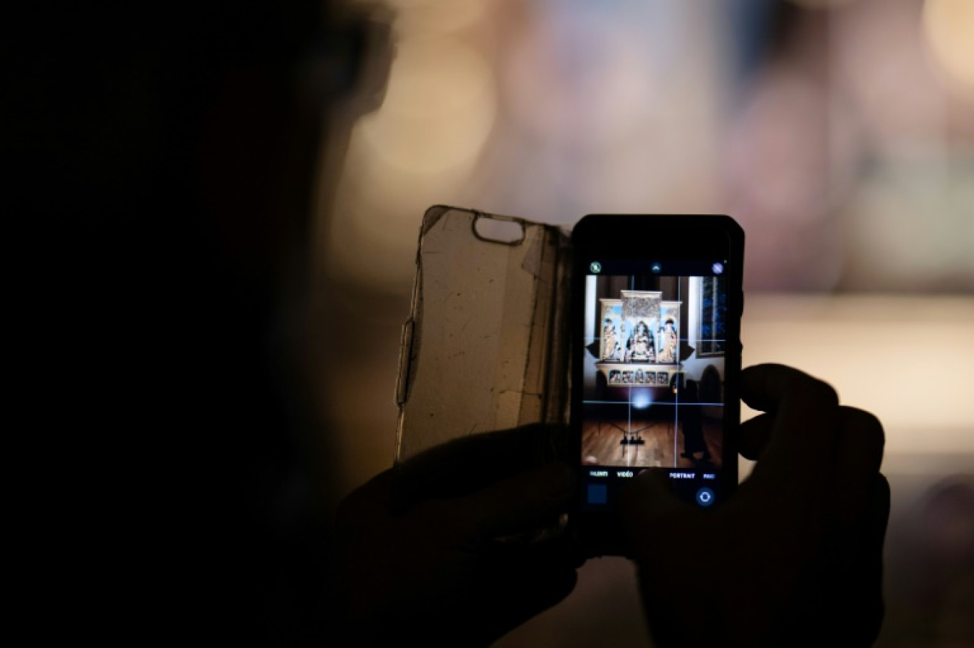 Un visiteur prend une photo lors d'une visite à la lampe torche du musée Unterlinden, le 23 janvier 2024 à Colmar © SEBASTIEN BOZON