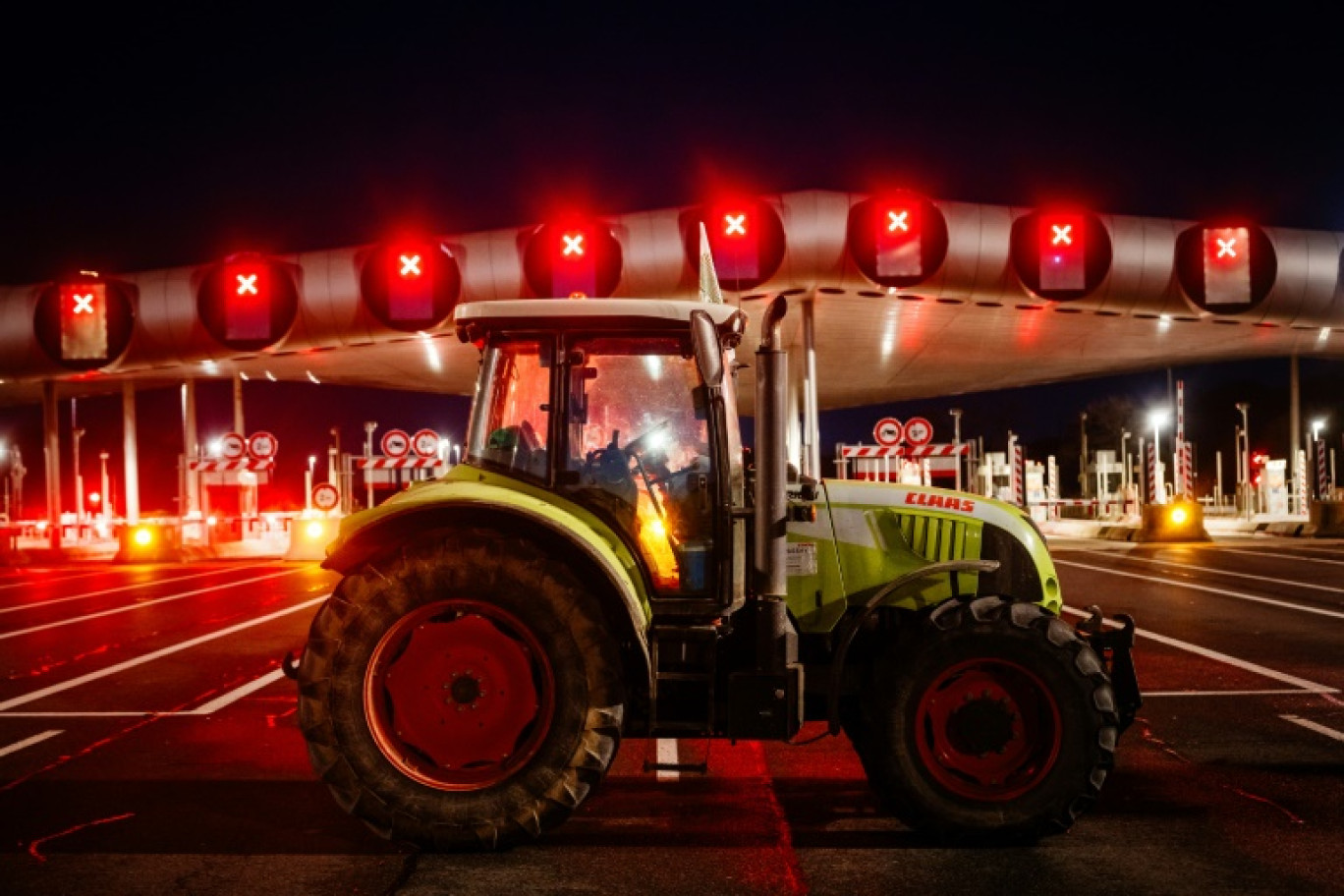 Des agriculteurs bloquent l'autoroute A10 avec des tracteurs, près des barrières de péage du Péage de Saint-Arnoult-en-Yvelines au sud-ouest de Paris, le 26 janvier 2024 © Dimitar DILKOFF