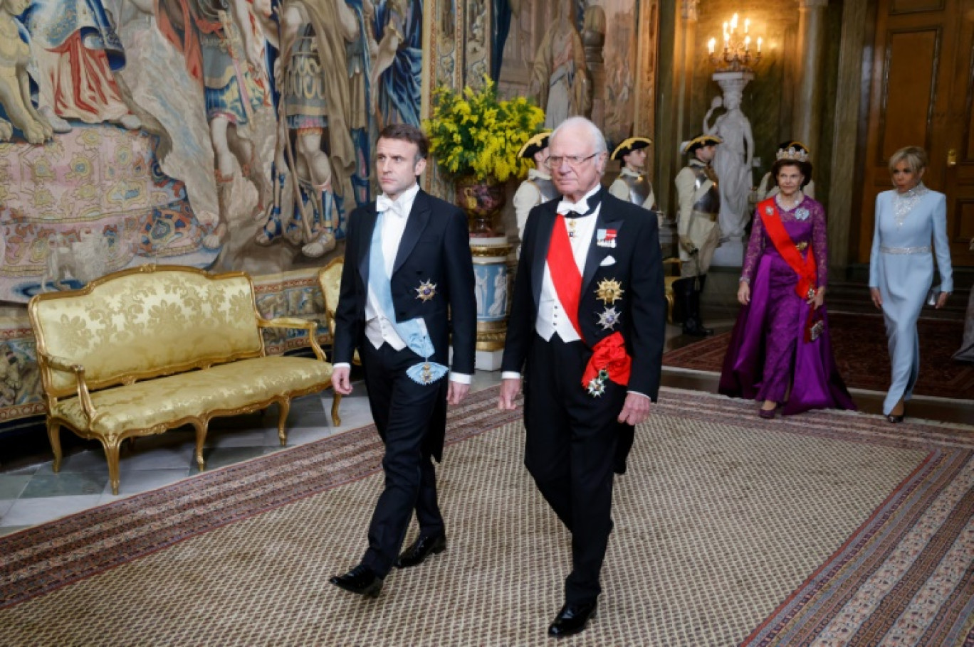 Le président français Emmanuel Macron (g) et le roi Carl XVI Gustaf de Suède, suivis par leurs épouses, la reine Sylvia (g, arrière-plan) et Brigitte Macron, arrivent au dîner d'État au Palais Royal de Stockholm, le 30 janvier 2024 © Ludovic MARIN