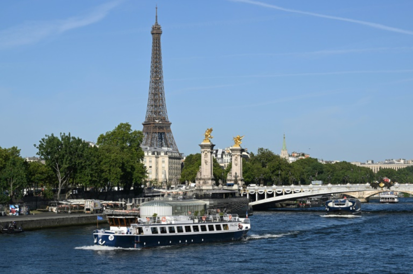 Une péniche passe devant la Tour Eiffel, sur la Seine, le 17 juillet 2023, lors d'un test des "manœuvres", "distances", "durée" et "capture vidéo" de la future cérémonie d'ouverture des JO de Paris en 2024 © Bertrand GUAY