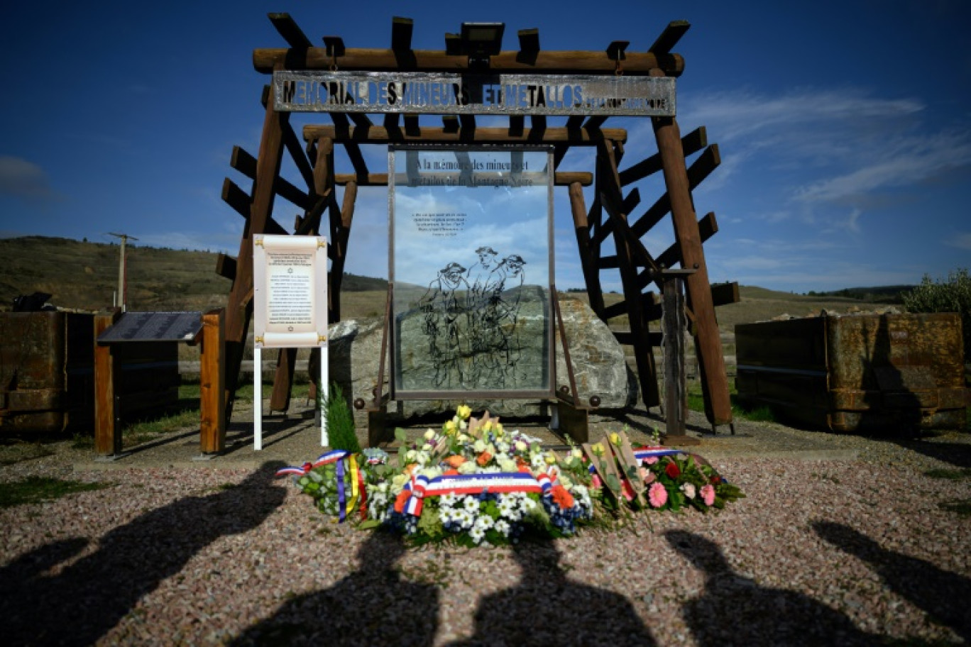 Des bouquets de fleurs et 13 roses jaunes lors d'une cérémonie au mémorial des mineurs de Salsigne pour honorer la rafle oubliée de treize mineurs juifs en janvier 1944, le 31 janvier 2024 dans l'Aude © Lionel BONAVENTURE