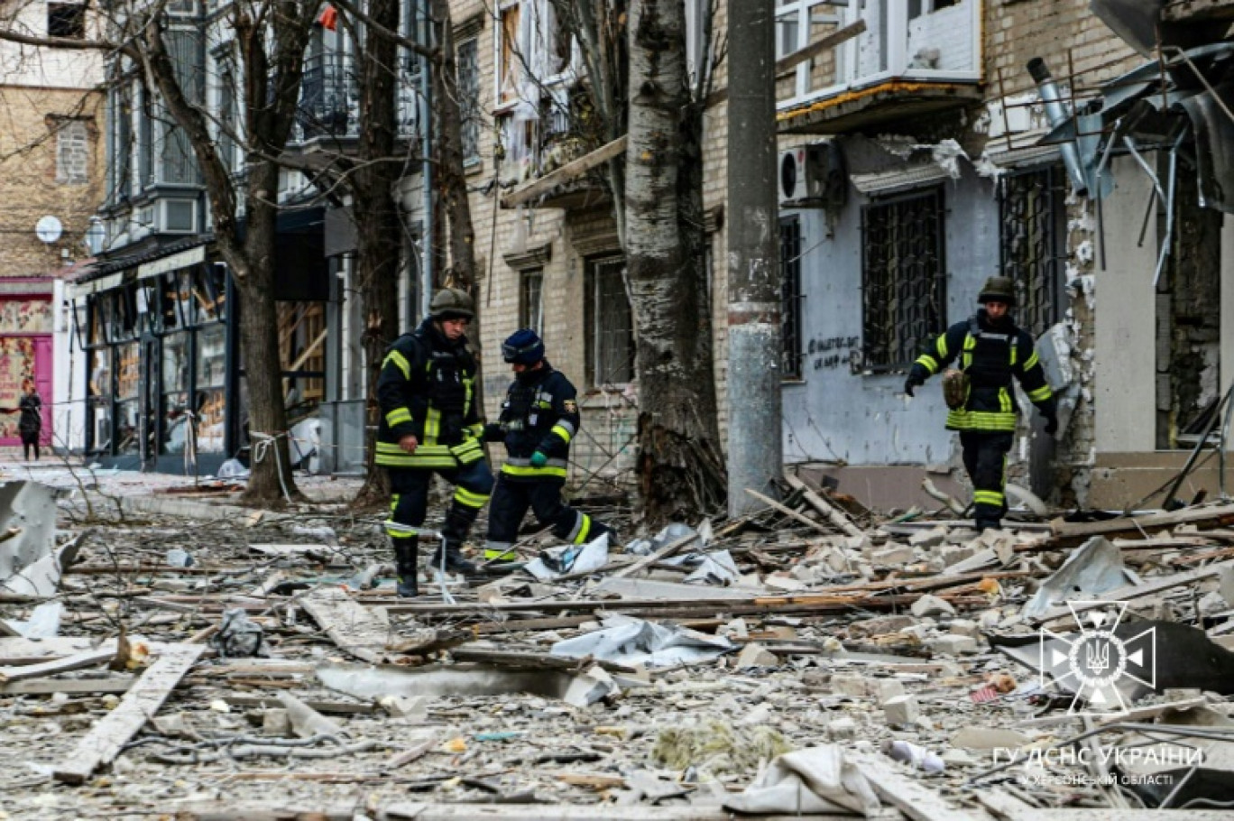 Photo diffusée par les services d'urgence ukrainiens, le 2 février 2024, de sauveteurs à l'extérieur de bâtiments endommagés par une frappe aérienne sur le centre de  Kherson, dans le sud de l'Ukraine © Handout