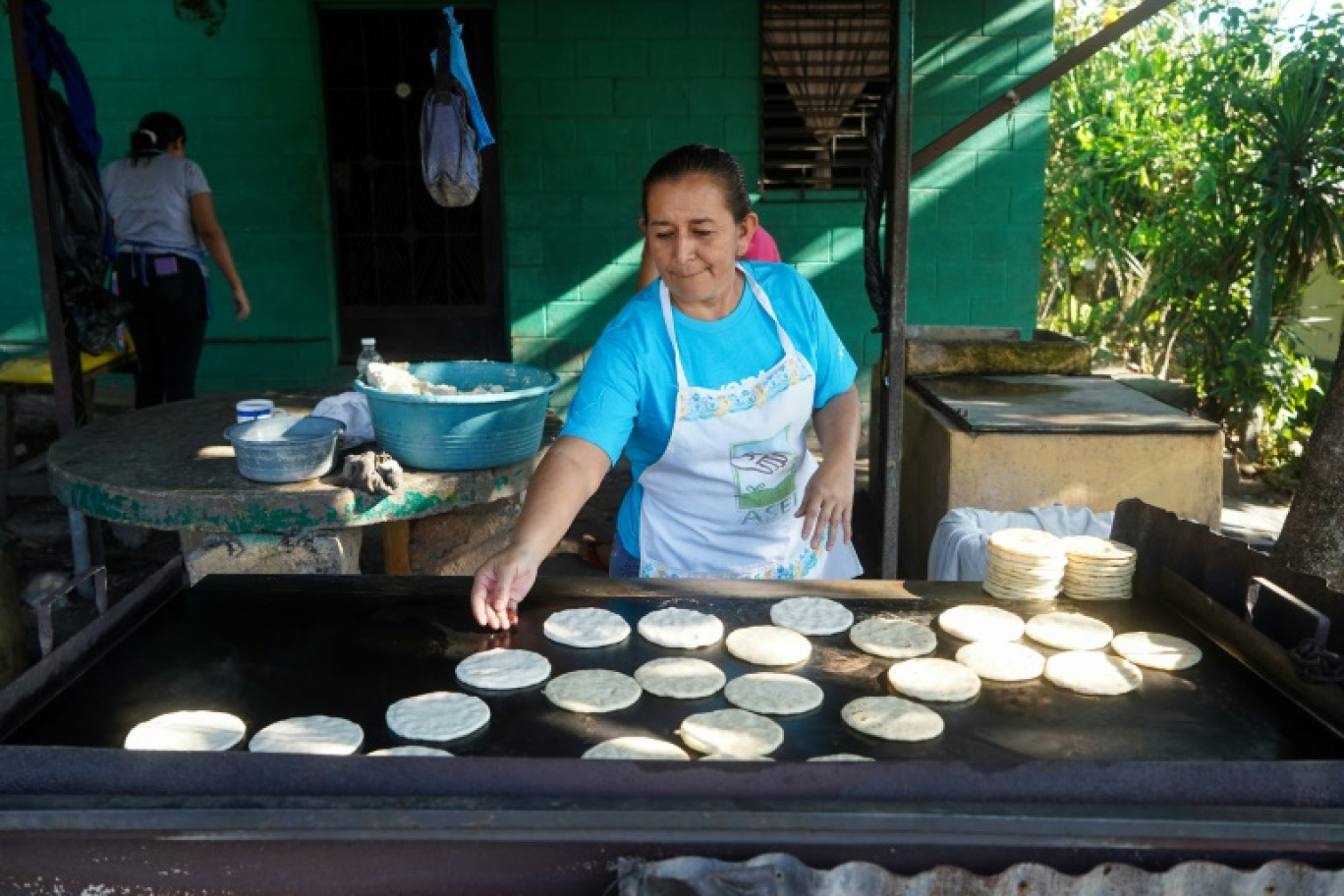 Une vendeuse prépare des tortillas sur son stand de rue pendant les élections présidentielles et législatives, à Soyapango, le 4 février 2024 au Salvador © Camilo FREEDMAN