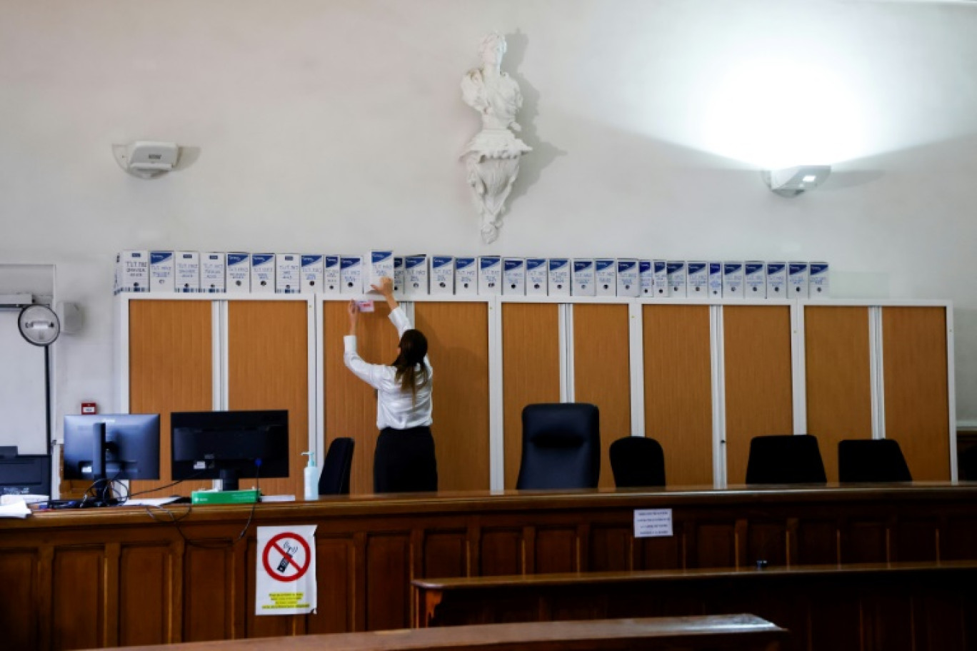 Une greffière recherche un dossier d'archives dans une salle d'audience du Tribunal de proximité, à Aubervilliers, au nord de Paris, le 22 janvier 2024 © Ludovic MARIN