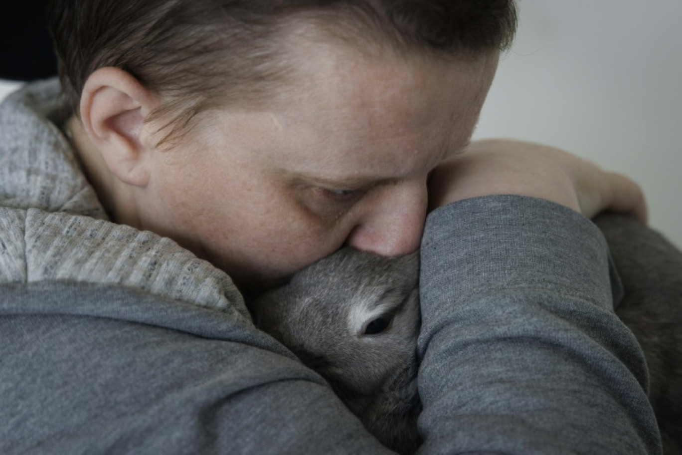 Lydie Imhoff serre dans ses bras sa lapine Lucky, dans son appartement vide à Besançon, à la veille de son départ pour une euthanasie en Belgique, le 30 janvier 2024 © Simon Wohlfahrt