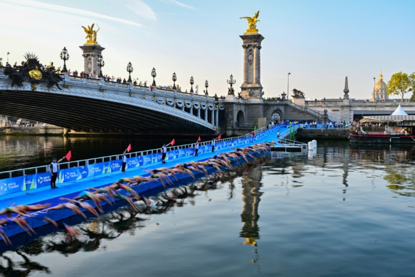 Des athlètes plongent dans la Seine, au niveau du pont Alexandre III, à Paris, lors d'une épreuve test du triathlon femmes pour les Jeux Olympiques 2024, le 17 août 2023 © Miguel MEDINA