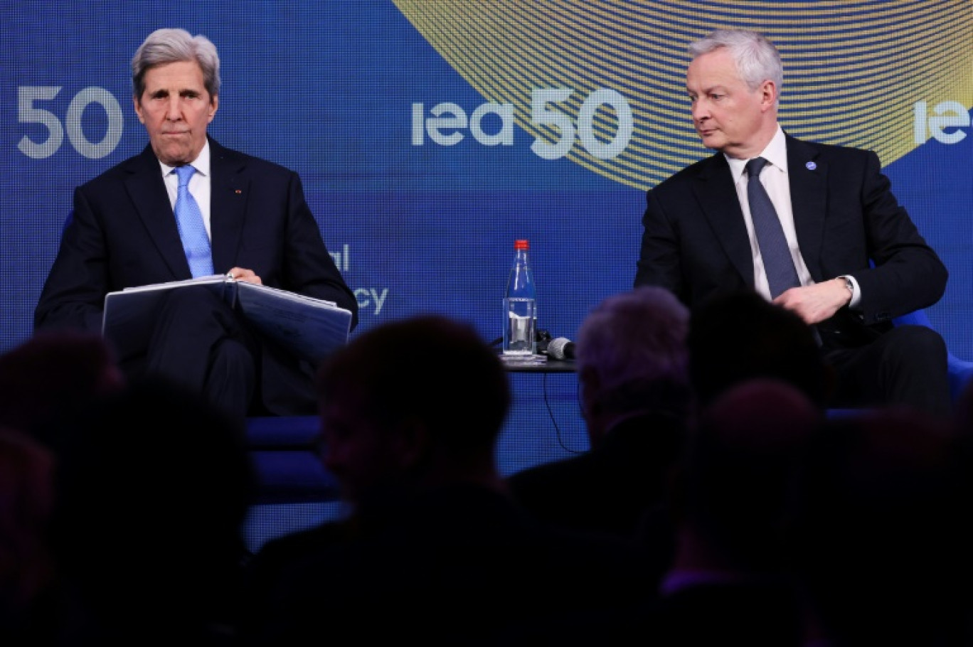 L'émissaire américain pour le climat John Kerry (g) et le ministre français de l'Économie et des Finances Bruno Le Maire assistent à une réunion ministérielle à l'occasion du 50e anniversaire de l'Agence internationale de l'energie (AIE, le 13 février 2024 à Paris © Ian LANGSDON