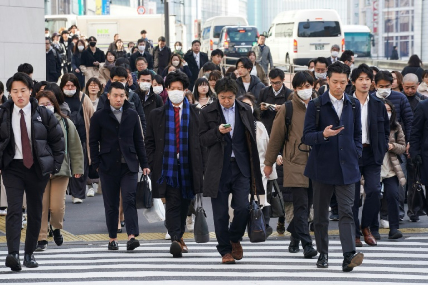 Des employés de bureau traversent un passage piéton à Tokyo, le 15 février 2024 © Kazuhiro NOGI