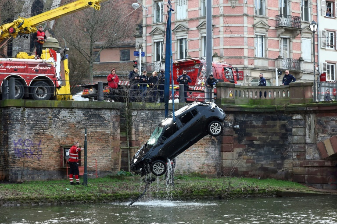 Une grue sort une voiture tombée dans l'Ill après un accident dans lequel deux personnes ont été tuées, le 15 février 2024 à Strasbourg, dans le Bas-Rhin © FREDERICK FLORIN