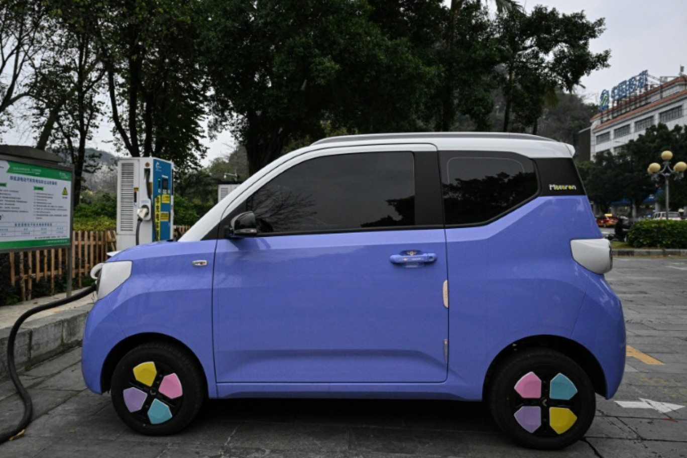 Un mini-véhicule électrique décoré à une borne de recharge à Liuzhou, dans le sud de la Chine, le 24 janvier 2024 © Jade GAO