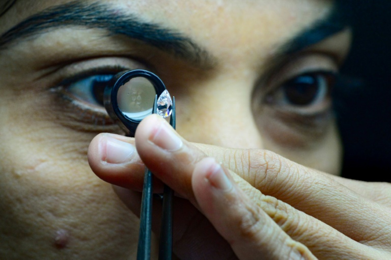 Un employé de Greenlab Diamonds examine un diamant de synthèse produit par son entreprise, le 6 février 2024 à Surate, en Inde, où 90% des diamants du monde sont taillés et polis © Sam PANTHAKY