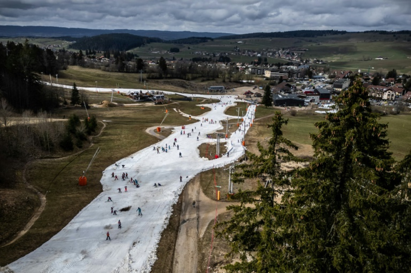 Une photographie aérienne prise le 20 février 2024 montre des pistes de ski dans un paysage sans neige dans la station du Jura français Métabief © Fabrice COFFRINI