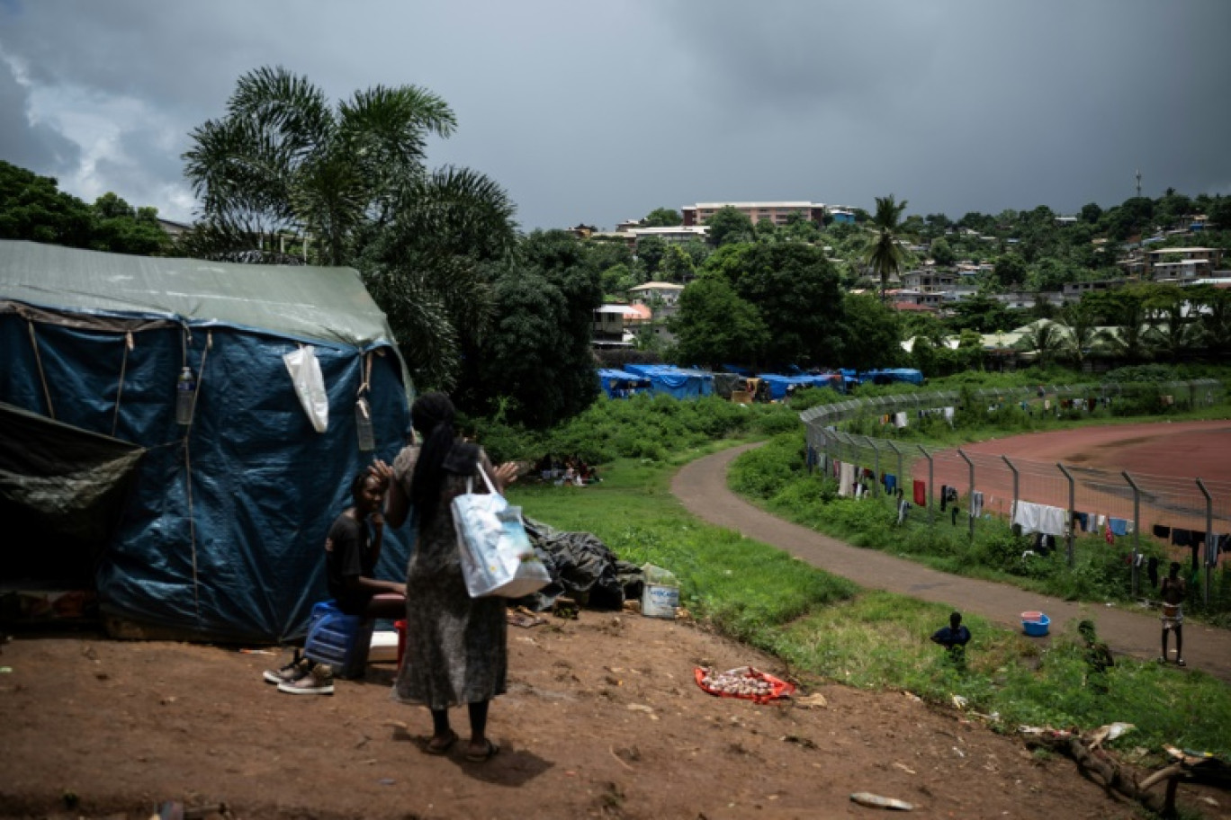 Des femmes parlent près d'une tente dans le camp de migrants de de Cavani, à Mamoudzou, le 15 février 2024 © JULIEN DE ROSA