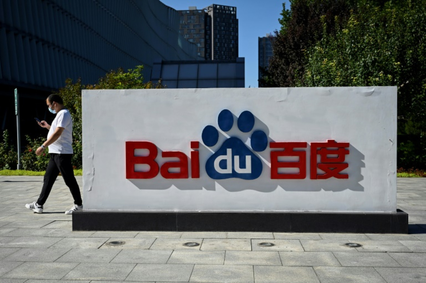 Un employé passe devant le logo du géant chinois de l'internet Baidu devant le siège du groupe à Pékin le 6 septembre 2022 © Jade GAO