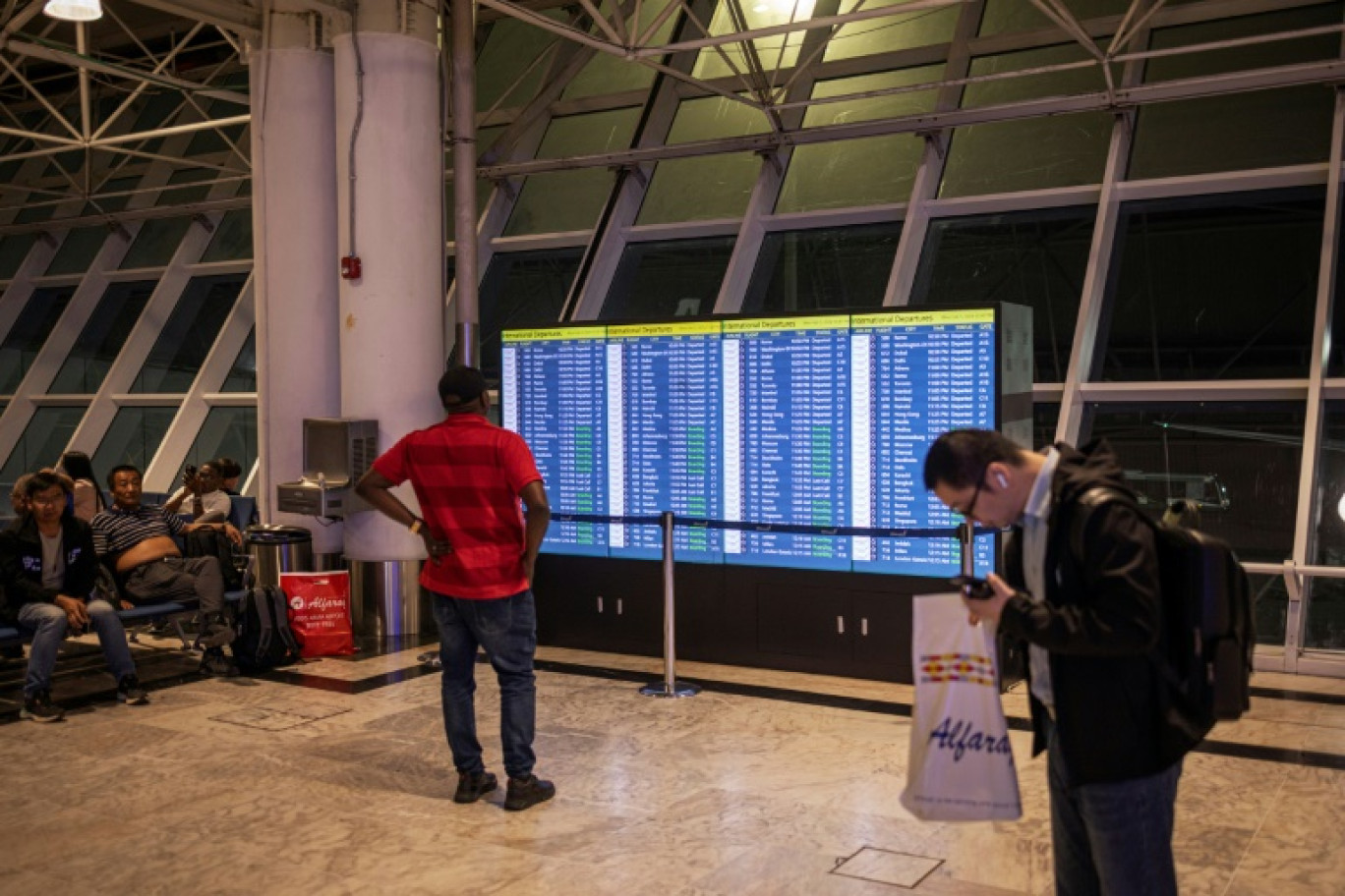 Un voyageur regarde un tableau d'information sur les vols à l'aéroport d'Addis Abeba, le 5 février 2024 en Ethiopie © Michele Spatari