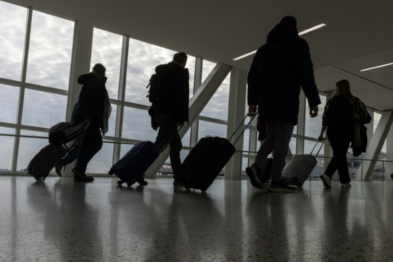 Des passagers et leurs valises à l'aéroport John F. Kennedy de New York, le 23 décembre 2023 © Jeenah Moon