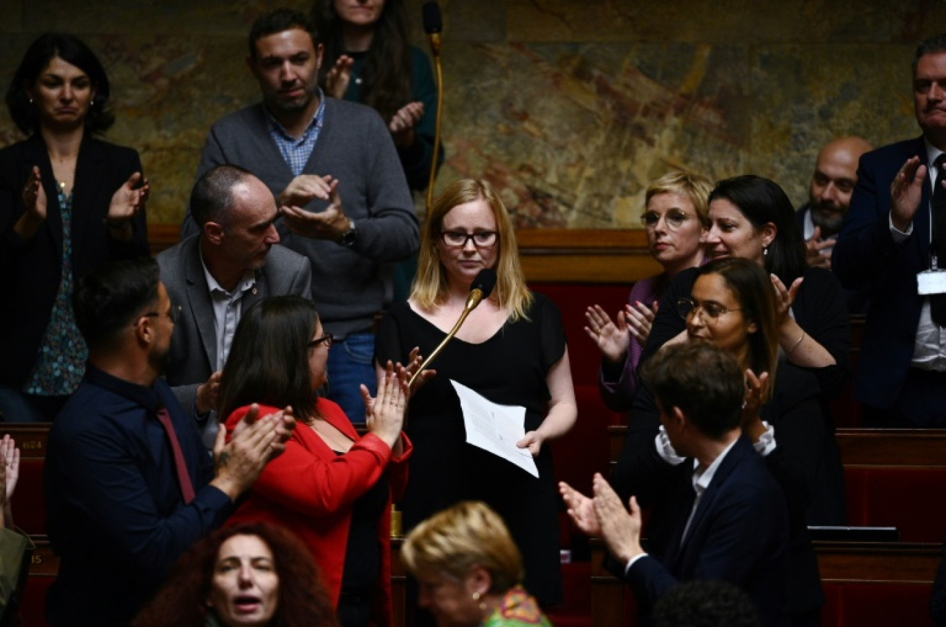 La député La France insoumise (LFI) Ersilia Soudais (c), applaudie par ses collègues, le 18 octobre 2022 à l'Assemblée nationale à Paris © Christophe ARCHAMBAULT