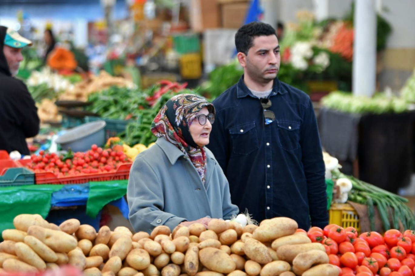 Des personnes devant un étal de légumes d'un marché à Tunis, le 6 mars 2024 © FETHI BELAID